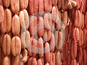 Fresh sausages hanging on hooks