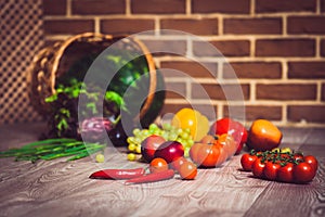 Fresh scattered vegetables and fruits. Overturned basket.