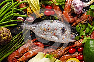 Fresh Sea bream or Dorado fish and prawns with ingredients photo