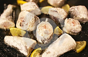 Fresh sea fish and lemon peces on ice surface. photo