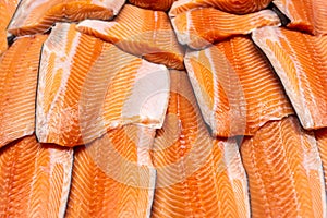 Fresh seafood on crushed ice at fish market. Raw salmon fillet on display counter at store. Fish filleting bacground photo