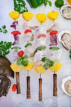 Fresh seafood mixed with various kinds of sea animals, including fish, shrimp, shellfish, arranged on ice and decorated with Vario