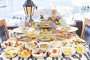 Seafoods, fish, salad and mezes on the table near the sea photo