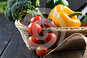 Fresh seasonal vegetables in basket on rustic wooden table