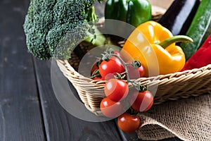 Fresh seasonal vegetables in basket on rustic wooden table