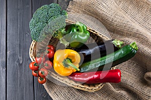 Fresh seasonal vegetables in basket on rustic wooden table