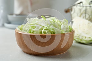 Fresh shredded cabbage on light table, closeup