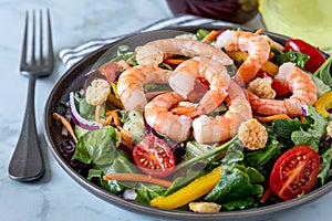 Fresh shrimp and greens salad on light background