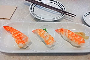 Fresh shrimp sushi served on white plate with ginger