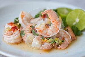 Fresh shrimp on white plate and fresh vegetables, cooked shrimps prawns and seafood spicy chili sauce coriander, cooking shrimp