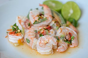 Fresh shrimp on white plate and fresh vegetables, cooked shrimps prawns and seafood spicy chili sauce coriander, cooking shrimp