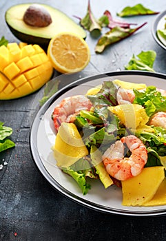 Fresh Shrimps, Avocado, Mango salad with lettuce green mix, herbs, lemon, healthy food.