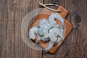 Fresh shrimps or prawns , Seafood shelfish for cooking - raw shrimp on wooden cutting board background