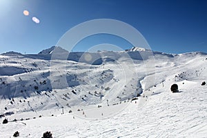 Fresh ski slopes and mountains in sunny day in Andorra