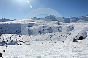 Fresh ski slopes and mountains in sunny day in Andorra