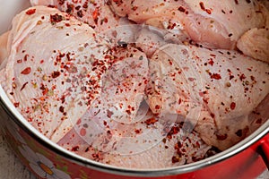 Fresh skinless chicken thighs. Raw chicken thigh. Chicken meat with seasonings paprika in a pan