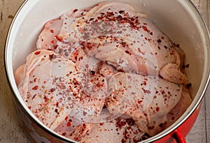 Fresh skinless chicken thighs. Raw chicken thigh. Chicken meat with seasonings paprika in a pan