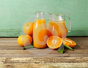 Fresh slice orange and bottle of juice on wooden background