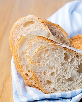 Fresh sliced baguette bread on wooden table.