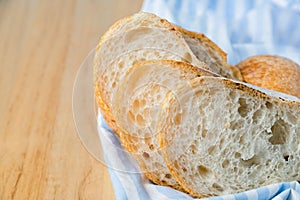 Fresh sliced baguette bread on wooden table.