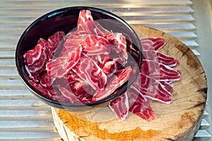 Fresh sliced beef hind shank in black ceramic bowl