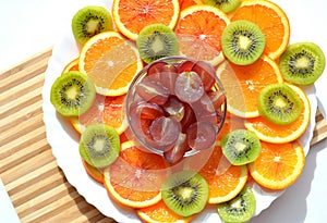 Fresh sliced fruits on a plate wood table top view background