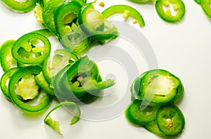 Fresh sliced green jalapeno peppers on a white background, spicy flavor ingredient in many dishes