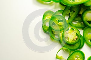 Fresh sliced green jalapeno peppers on a white background, spicy flavor ingredient in many dishes