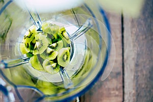 Fresh sliced kiwi fruit on electric equipment juice smoothie ingredients and blender. Healthy drink menu