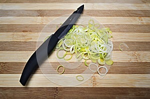 Fresh sliced leeks on a wooden board.