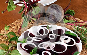 Fresh sliced organic beetroot with onion decorated on a white plate