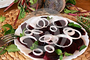 Fresh sliced organic beetroot with onion decorated on a white plate