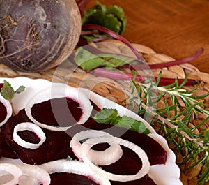 Fresh sliced organic beetroot with onion decorated on a white plate