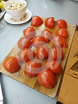 fresh sliced tomatoes on the wooden plate with pistachios