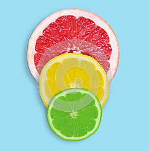Fresh slices of grapefruit, lemon and lime on a blue background