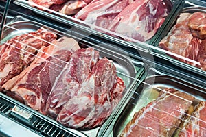 Fresh slices of raw pork meat on counter in supermarket