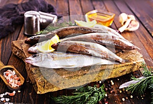 Fresh small fish on stone board