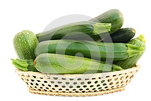 Fresh small green vegetable marrows in a basket