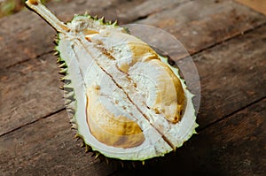 Fresh smelly yellow Durian fruits half cut open on old wood background