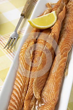 Smoked salmon bellies on a plate close up
