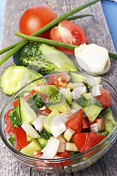 Fresh snack from sliced organic vegetables on wooden board in closeup. Rustic healthy food