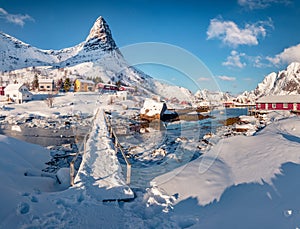 Fresh snow covered footpath bridge over Gravdalbukta bay