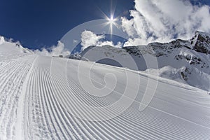 Fresh snow groomer tracks on a ski piste