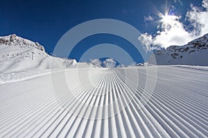 Fresh snow groomer tracks on a ski piste