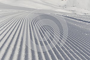 Fresh snow groomer tracks on a ski piste