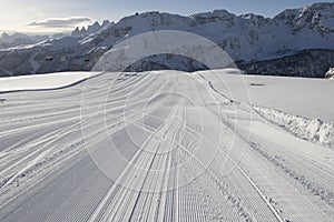 Fresh snow groomer tracks on a ski piste