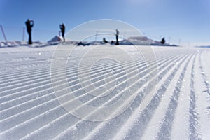 Fresh snow groomer tracks on a ski piste