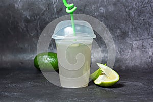 Fresh Soda Lemonade drink with lemon slice and straw served in disposable cup isolated on grey background top view of indian and