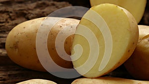 Fresh Solanum tuberosum potatoes, Irish potato on wooden background.