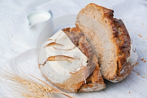 Fresh sourdough bread with a coffee mug on white fabric.